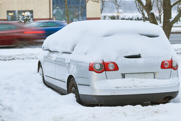 City winter snowfall. Car covered with snow on street