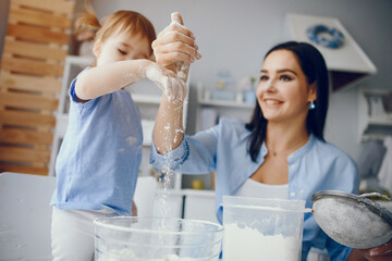 Family in a kitchen. Beautiful mother with little daughter. Woman in a blue shirt