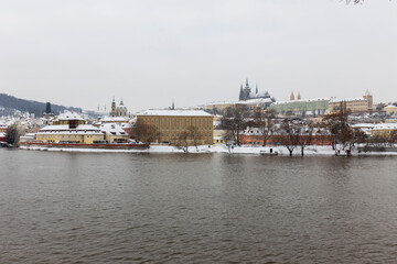 Naklejka premium Snowy Prague Lesser Town with Prague Castle above River Vltava, Czech republic