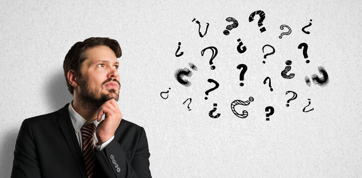 thinking businessman with many question marks on paper background