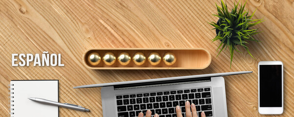 stylized loading bar with the word SPANISH in Spanish and office equipment on wooden background