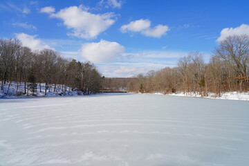 Fototapeta na wymiar Snowy day view of the frozen lake at the Mountain Lakes Preserve in Princeton, New Jersey, United States, after a major snowfall