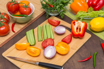 Different vegetables for cooking healthy vegetarian vegan diet food. Cutting vegetables on wooden board on kitchen 