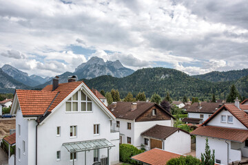 A great view of the Alps and an old German cityl on background of mountains under cloudy sky.