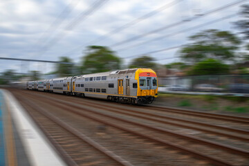 Fototapeta na wymiar Commuter Train fast moving through a Station in Sydney NSW Australia