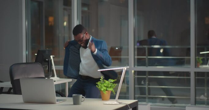Funny happy afro-american male employee dancing in office