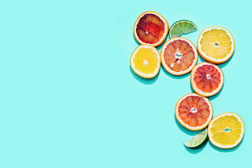 Bright slices citrus fruits, grapefruit, red orange, lemon, lime on pastel turquoise background. Minimal fruit and summer concept.