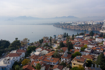 Naklejka na ściany i meble Aerial panoramic view of the Antalya city. Mediterranean sea, and the coast of Antalya. Old town Kaleici, Yacht Marina, mountains and cloudy sky in the background. Aerial drone shooting. TURKEY
