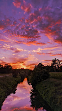 Flowing Creek Gleaming Under The Beautiful Cloudy Pink Sky In The Park