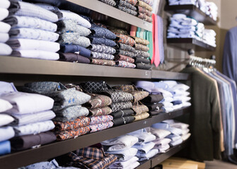 Assortment of shirts in menswear clothing store for selling, textile industry concept