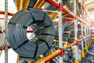 Factory stock wire. Wire spools lie on multi-tiered racks.