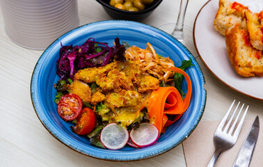 Vegetable salad with chicken, carrots, tomatoes and radishes and red cabbage