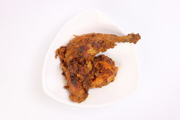 Indian style chicken curry pot roasted leg on white triangle dish over white background