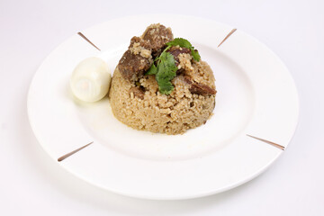 Beef Biryani Tehari cooked in mustered oil with boiled egg coriander leaf garnish on white plate over white background