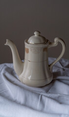 beautiful old tea pot or coffee maker. With a beige background on a white cloth.