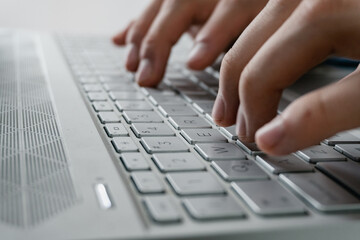 man's hand typing on a modern all-gray computer