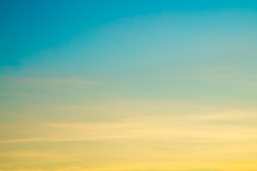 Sunset sky replacement for photoshop, lightroom edit. Yellow, orange, pastel tones fading into blue above wispy, flat clouds. 