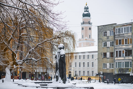 DROHOBYCH, UKRAINE - FEBRUARY 10, 2021: Monument to a Ukrainian philosopher Yuriy Drohobych and the Tower of Drohobych Town Hall.