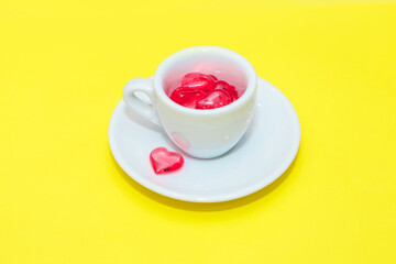 cup with hearts on a red background. the view from the top. red hearts spilled out. isolated on a pink background. copy space. panton