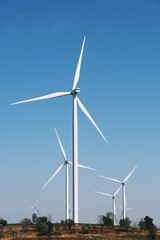Wind turbines on beautiful sunny summer autumn mountain landsape. Curvy road through mountain Eolic...