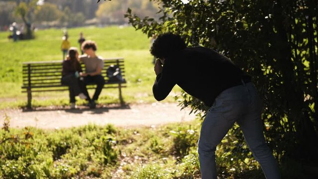 Private Detective - Man Hiding In The Bushes Photographs A Couple