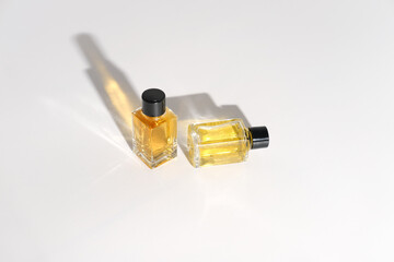 two perfume bottles on a white background. travel size fragrance bottles. sample mini perfume for women. trendy direct light. 