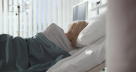 Back view of sick woman sleeping on side in hospital bed - Powered by Adobe