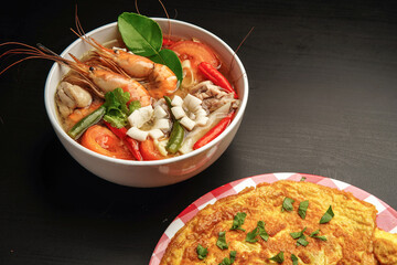 delicious tomyam seafood thai dish with freshwater prawn and black background