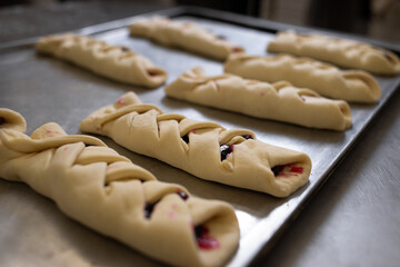 A roll filled with currant and raspberry jam lies on a metal board. Preparation for baking. Homemade cakes.