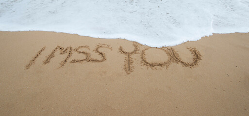 I miss you written in the sand with finger