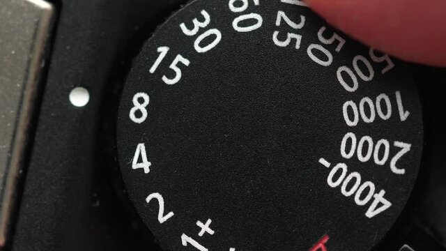 Running a dial of a camera to change the shutter speed value