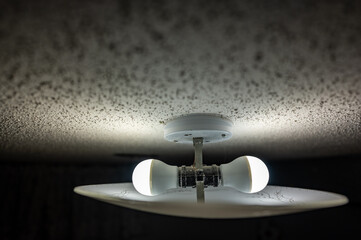 popcorn textured ceiling with LED bulb light fixture and glass cover