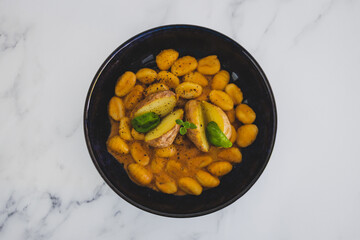 vegan gnocchi with dairy-free pumpkin sauce and roasted potatoes with basil