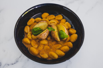 vegan gnocchi with dairy-free pumpkin sauce and roasted potatoes with basil