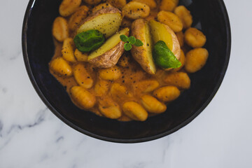 vegan gnocchi with dairy-free pumpkin sauce and roasted potatoes with basil