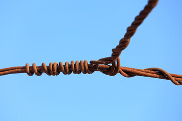 Oxidized and rusty wire against a blue background