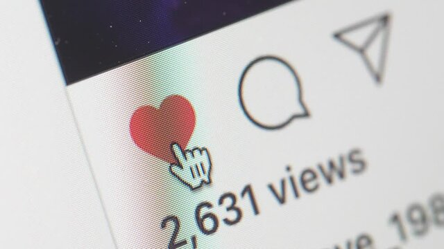 Clicking on the heart like button on social media to show appreciation close-up shot
