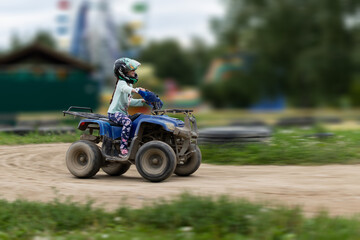 Fototapeta na wymiar a child rides an ATV on the track