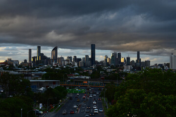 Fototapeta premium city skyline under brooding clouds with busy road in foreground