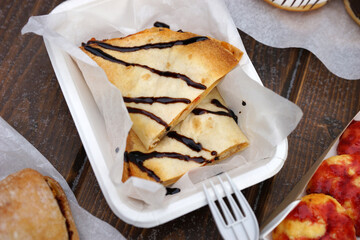 Street food and coffee on a wooden table in the street in winter