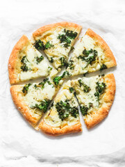 Slice of vegetarian potato, kale cabbage, mozzarella cheese pizza on a light background, top view