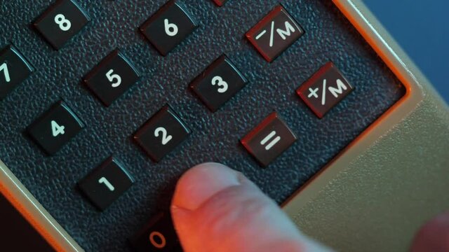 Using a vintage calculator to calculate numbers by pressing the buttons close-up shot of the 80s 90s