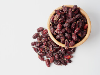 Dried berries of Dog Rose or Rosa canina. Dry fruits of sweet-brier or rose hips on wooden background. Healthy and herbal concept. Selective focus. Natural vitamin, nutritional supplement for health