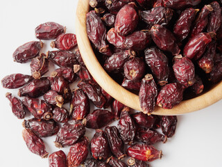 Dried berries of Dog Rose or Rosa canina. Dry fruits of sweet-brier or rose hips on wooden background. Healthy and herbal concept. Selective focus. Natural vitamin, nutritional supplement for health