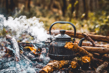 Old vintage black pot on Firewood burning. kettle on fire