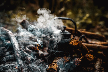Old vintage black pot on Firewood burning. kettle on fire