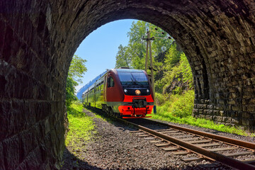 Naklejka na ściany i meble Commuter train pulls into tunnel