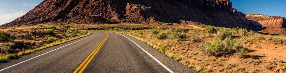Wide shot of road zigzagging in desert near canyonlands at sunny day in Utah, america