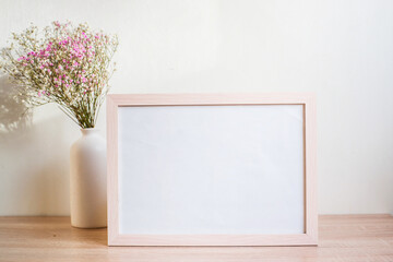 Horizontal white frame mockup on vintage wooden bench, table. Modern white ceramic vase gypsophila....
