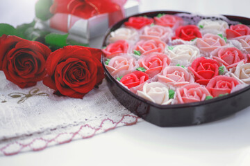 Obraz na płótnie Canvas Rose shaped dessert in a heart shape gift box for Valentine's Day, with rose flower and gift box near by, presents for Valentine's day